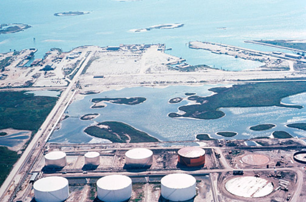 Aerial view of refinery tanks beside coastal waterways
